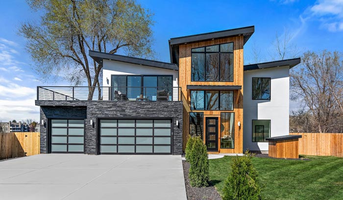 modern house with wood panels and glass garage doors